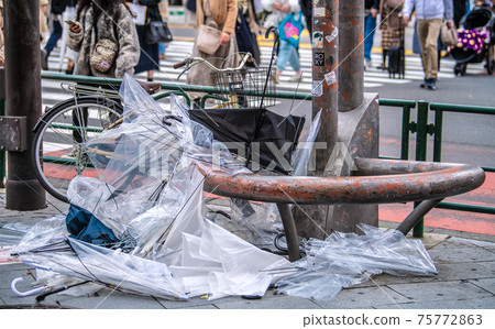 Tokyo cityscape of Japan: The scars of a spring storm ... There is a mountain of umbrellas beside the intersection. On the first day of declaring cancellation, many people ... = March 22 75772863