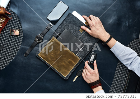 Set of handmade leather goods in male hands, key holder rings, wallet, purse, notepad, handbook. Handcrafted leather goods, close-up Set of handmade leather goods in male hands, key holder rings, wallet, purse, notepad, handbook. Handcrafted leather goods, close-up 75775313