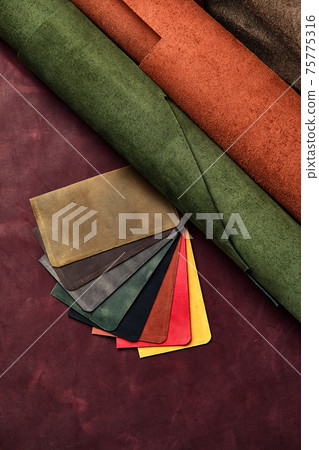Artificial leather samples on a cow leather background. Top view. Artificial leather samples on a cow leather background. Top view. 75775316