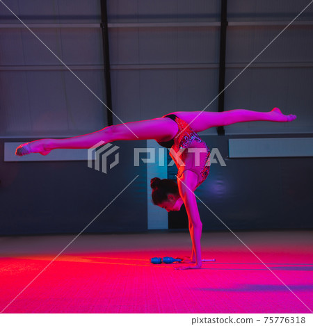 Young female rhythmic gymnast isolated on multicolored background in neon light 75776318