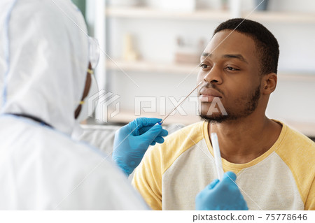 Black guy receiving nasal PCR test while staying home 75778646