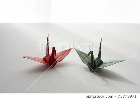 Two origami cranes on a white background 75778971