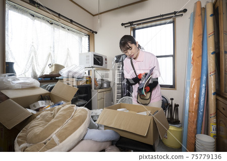 女工收拾一間凌亂的房間 75779136