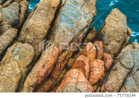 Close up view bright vivid orange brown yellow stone rock shabby cliff cracks texture mountains. Concept of geology, beauty power in nature. Natural summer composition landmark background design Close up view bright vivid orange brown yellow stone rock shabby cliff cracks texture mountains. Concept of geology, beauty power in nature. Natural summer composition landmark background design 75779294