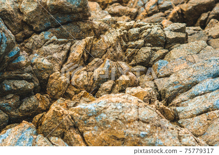Close up view bright vivid orange brown yellow stone rock shabby cliff cracks texture mountains. Concept of geology, beauty power in nature. Natural summer composition landmark background design 75779317