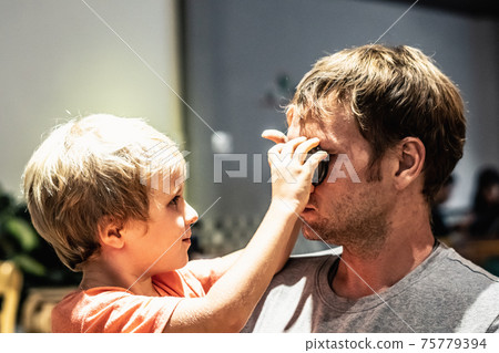 Cute son little blond child boy play with Father face, eyes closed with pleasure, funny mischievous, face to head, inside room. Happy childhood, fatherhood love feelings, fathers day, real skin Cute son little blond child boy play with Father face, eyes closed with pleasure, funny mischievous, face to head, inside room. Happy childhood, fatherhood love feelings, fathers day, real skin 75779394