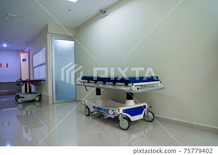 Patient bed on pathway in the hospital and wheelchairs Patient bed on pathway in the hospital and wheelchairs 75779402