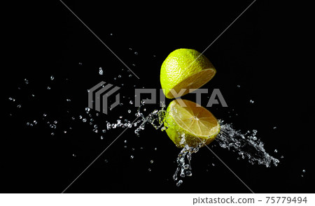 Juice splashes out of a cut lime. Juice splashes out of a cut lime. 75779494