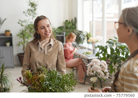 Smiling Young Woman in Florists Workshop Smiling Young Woman in Florists Workshop 75779560