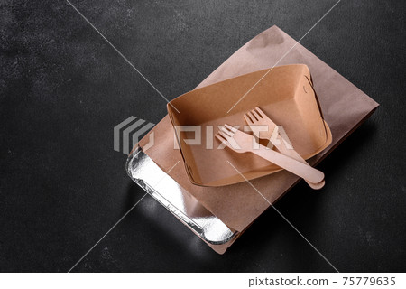 Disposable dishes made of environmentally friendly brown cardboard on a dark background Disposable dishes made of environmentally friendly brown cardboard on a dark background 75779635
