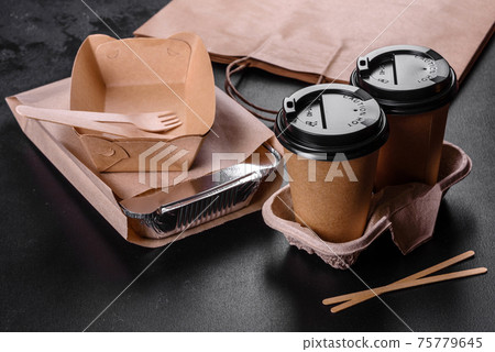 Disposable dishes made of environmentally friendly brown cardboard on a dark background Disposable dishes made of environmentally friendly brown cardboard on a dark background 75779645