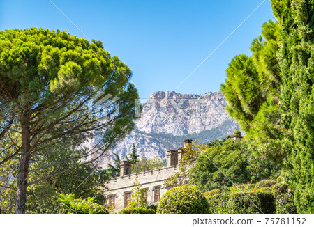 The walls and towers of the old palace on the background of high mountains and blue sky The walls and towers of the old palace on the background of high mountains and blue sky 75781152
