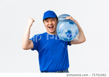 Office and home delivery and employees concept. Cheerful asain male courier in blue uniform, carry bottle with clean water on shoulder, bring order to client and fist pump, best delivering company Office and home delivery and employees concept. Cheerful asain male courier in blue uniform, carry bottle with clean water on shoulder, bring order to client and fist pump, best delivering company 75781882