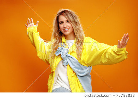Trendy fashionable woman dancer posing against yellow backgorund Trendy fashionable woman dancer posing against yellow backgorund 75782838