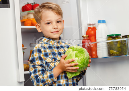 Little boy standing near the open fridge Little boy standing near the open fridge 75782954