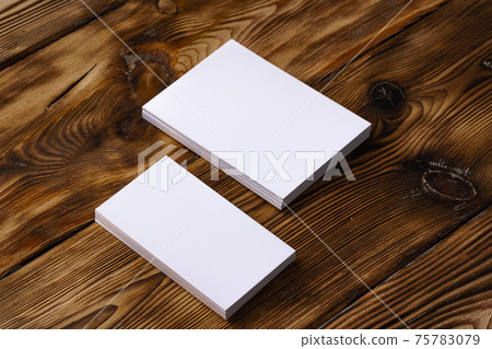 Stack of white business cards on brown wooden background 75783079