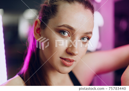 Portrait of a young sporty caucasian woman training in a fitness club 75783440