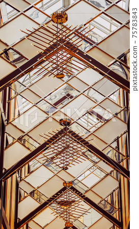 Stylish geometric ceiling of the building, dome with metal frame details. Graphic modern background Stylish geometric ceiling of the building, dome with metal frame details. Graphic modern background 75783843