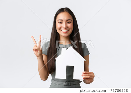 Insurance, loan, real estate and family concept. Smiling attractive asian woman selling or buying apartment, showing peace kawaii sign and paper house, saleswoman showing home, white background Insurance, loan, real estate and family concept. Smiling attractive asian woman selling or buying apartment, showing peace kawaii sign and paper house, saleswoman showing home, white background 75786338