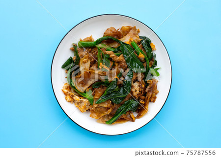 Stir fried flat noodle and pork with soy sauce. 75787556