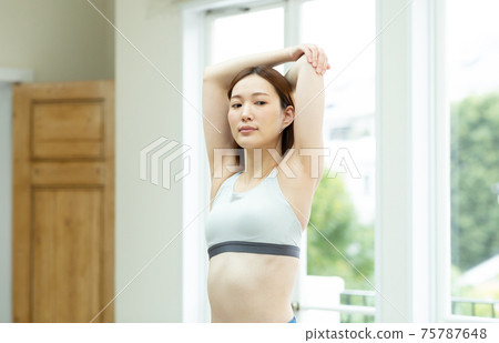 一個女人在她的房間裡伸展 一個女人在她的房間裡伸展 75787648