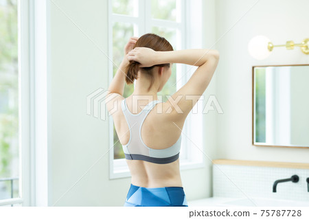 A woman stretching in her room 75787728