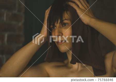 Young man wiping hair with towel 75788846