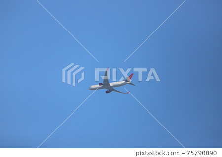 An airplane flying over Odawara 75790090