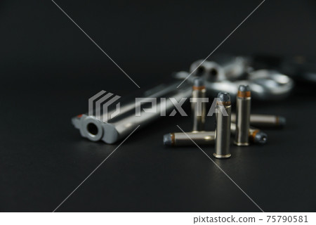 357 Caliber hollow point bullets near revolver pistol gun on black background 75790581