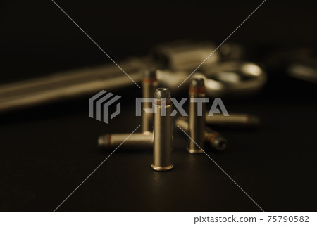 357 Caliber hollow point bullets near revolver pistol gun on black background 357 Caliber hollow point bullets near revolver pistol gun on black background 75790582