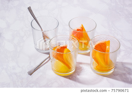 Lemonade prepearing with oranges, lemons and grapefruit. glasses with fruit slices on white table Lemonade prepearing with oranges, lemons and grapefruit. glasses with fruit slices on white table 75790671