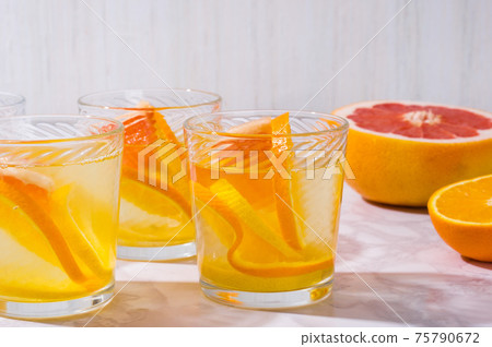 citrus lemonade and ingredients on white table. Fresh  mixed fruits drink. Healthy eating, dieting 75790672