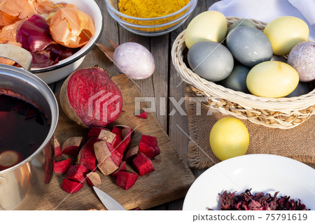 Process of coloring Easter eggs with various food natural dyes. Preparing for Easter. 75791619