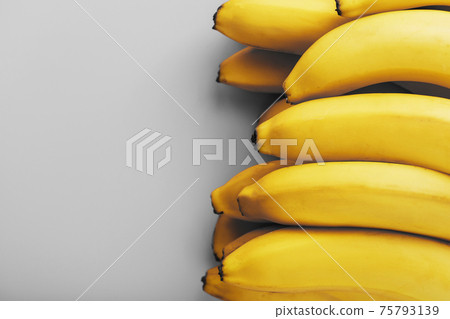Fresh bunch of yellow bananas isolated on a Gray background Trendy colors of 2021 Fresh bunch of yellow bananas isolated on a Gray background Trendy colors of 2021 75793139