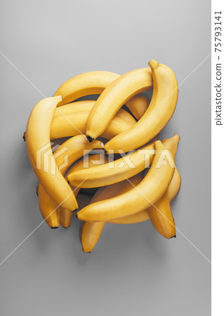 A bunch of fresh yellow bananas on a gray background in the fashionable colors of 2021 A bunch of fresh yellow bananas on a gray background in the fashionable colors of 2021 75793141