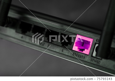 A pink patch cord is inserted into the router's Wi-Fi port to access the Internet. Internet connection over a wire with a router. A pink patch cord is inserted into the router's Wi-Fi port to access the Internet. Internet connection over a wire with a router. 75793143
