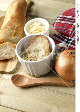 French bread, cheese, spoon, onion, mittens around hot onion gratin soup 75793984