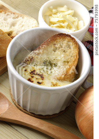 French bread, cheese, spoon, onion, mittens around hot onion gratin soup 75793998