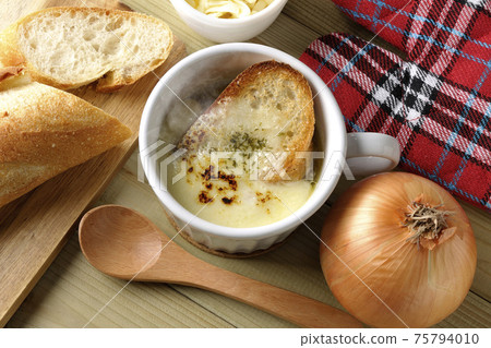 French bread, cheese, spoon, onion, mittens (overhead view) around hot onion gratin soup French bread, cheese, spoon, onion, mittens (overhead view) around hot onion gratin soup 75794010
