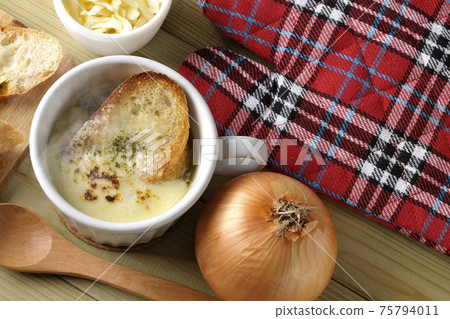 French bread, cheese, spoon, onion, mittens (overhead view) around hot onion gratin soup French bread, cheese, spoon, onion, mittens (overhead view) around hot onion gratin soup 75794011