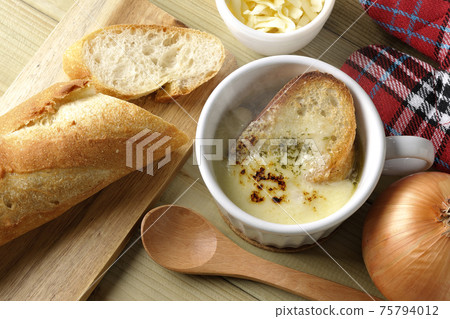 French bread, cheese, spoon, onion, mittens (overhead view) around hot onion gratin soup 75794012