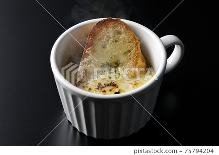 在黑色背景上一杯吃的熱洋蔥焗烤湯 在黑色背景上一杯吃的熱洋蔥焗烤湯 75794204