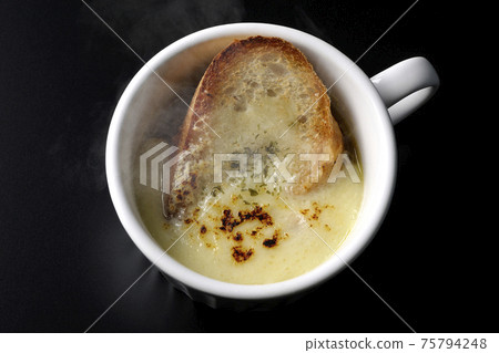 在黑色背景上的杯子裡吃的熱洋蔥焗烤湯(頂視圖) 在黑色背景上的杯子裡吃的熱洋蔥焗烤湯(頂視圖) 75794248