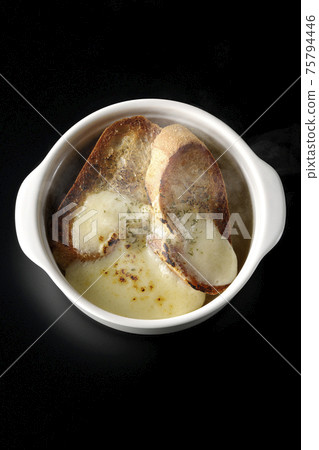 拍攝的熱洋蔥湯,用焦燒的奶酪和法國麵包在黑色的背景(頂視圖) 拍攝的熱洋蔥湯,用焦燒的奶酪和法國麵包在黑色的背景(頂視圖) 75794446