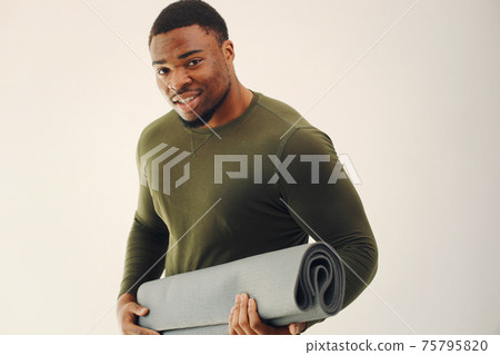 Handsome black man doing yoga on a white background Handsome black man doing yoga on a white background 75795820