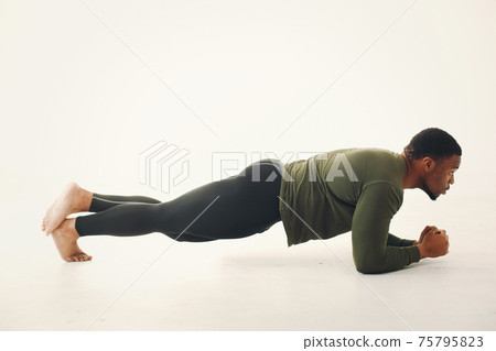 Handsome black man doing yoga on a white background Handsome black man doing yoga on a white background 75795823