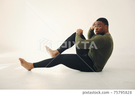 Handsome black man doing yoga on a white background Handsome black man doing yoga on a white background 75795828