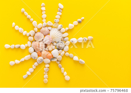 Abstract sun from sea pebbles and seashells Abstract sun from sea pebbles and seashells 75796468