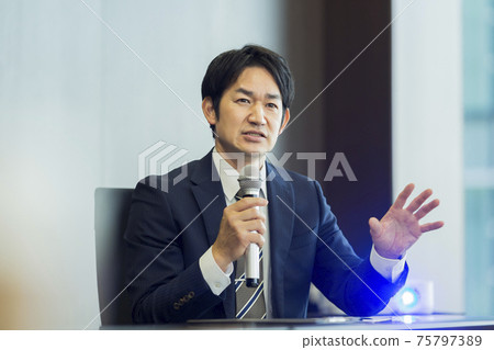 A businessman talking with a microphone A businessman talking with a microphone 75797389