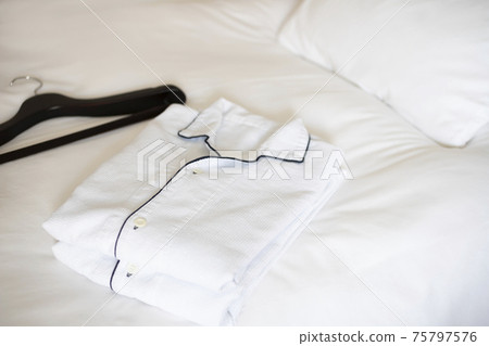 Pajamas and hangers on the hotel bed Pajamas and hangers on the hotel bed 75797576